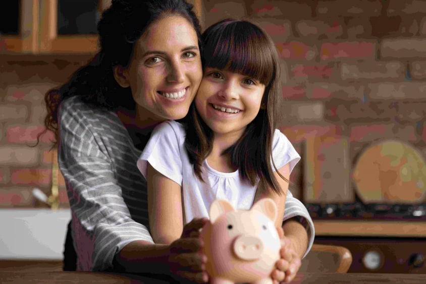 Mujer y niña guardando monedas en una alcancía