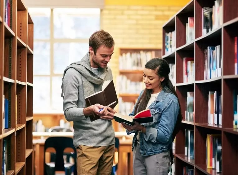 Personas estudiando en la biblioteca de una universidad del exterior