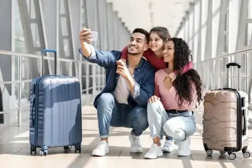 Una familia de tres personas preparándose para su viaje en un aeropuerto