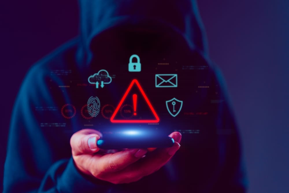 Alerta en teléfono móvil sobre intentos de smishing y fraudes bancarios en línea.