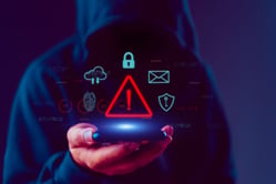 Alerta en teléfono móvil sobre intentos de smishing y fraudes bancarios en línea.