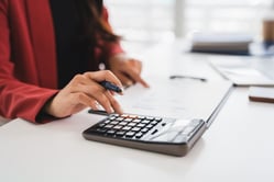 Persona usando una calculadora para medir el ciclo de conversión de efectivo de una empresa