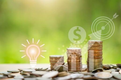 Monedas apiladas en un frasco de vidrio para ilustrar el crecimiento de la rentabilidad en un CDT o cuenta de ahorros.