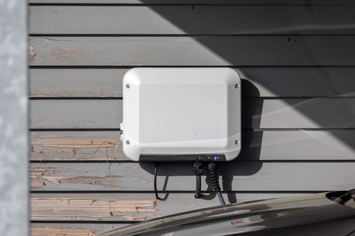 Cargador eléctrico nivel 2 tipo wallbox instalado en la pared de un garaje residencial a 220 V.