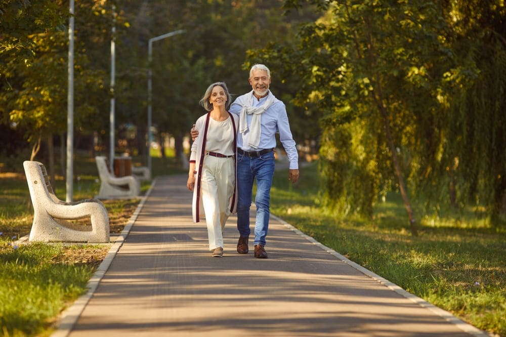 Pareja de pensionados sonrientes disfrutando de tranquilidad económica y estabilidad en su hogar