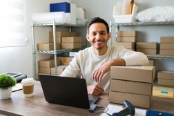 Emprendedor revisando opciones de préstamos en línea en su computador para financiar su negocio.