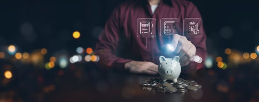 Escritorio con calculadora, gráficos de planificación financiera y una persona revisando un presupuesto, representando la organización de finanzas personales en Colombia.