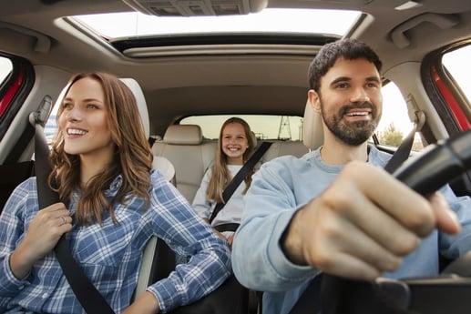 Familia sonriente viajando en auto usado adquirido mediante crédito sin descapitalizarse