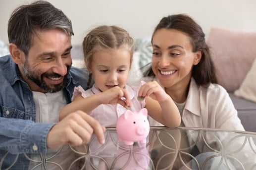 Padres enseñando educación financiera a su hija para mejorar las finanzas en pareja con hijos.
