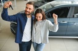 Pareja sonriente evaluando opciones para financiar un vehículo usado sin descapitalizarse