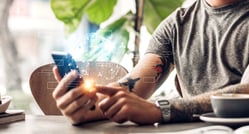 Un hombre de negocios utiliza su celular para gestionar cuentas y transacciones a través de plataformas de open finance.