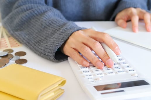 Persona calculando los gastos mensuales del hogar y aplicando estrategias de ahorro en su presupuesto familiar.