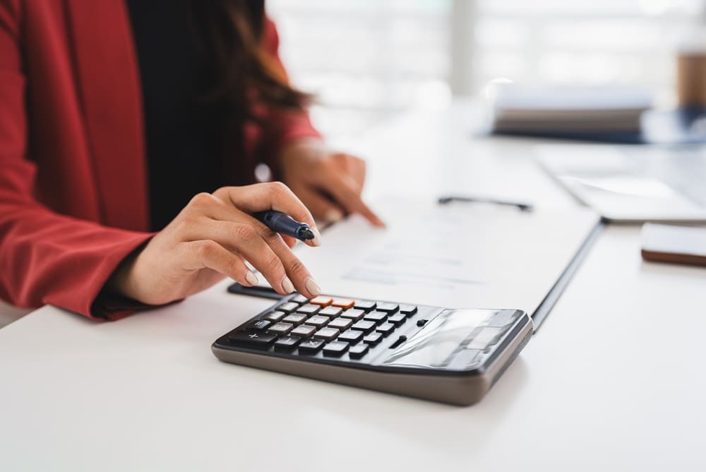 Persona usando una calculadora para medir el ciclo de conversión de efectivo de una empresa