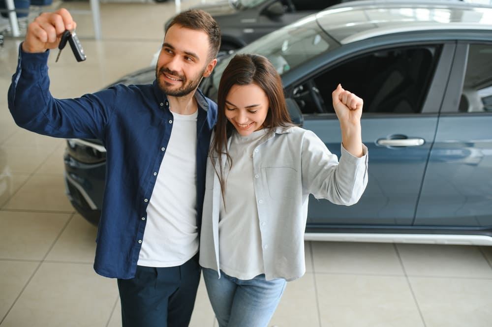 Pareja sonriente evaluando opciones para financiar un vehículo usado sin descapitalizarse