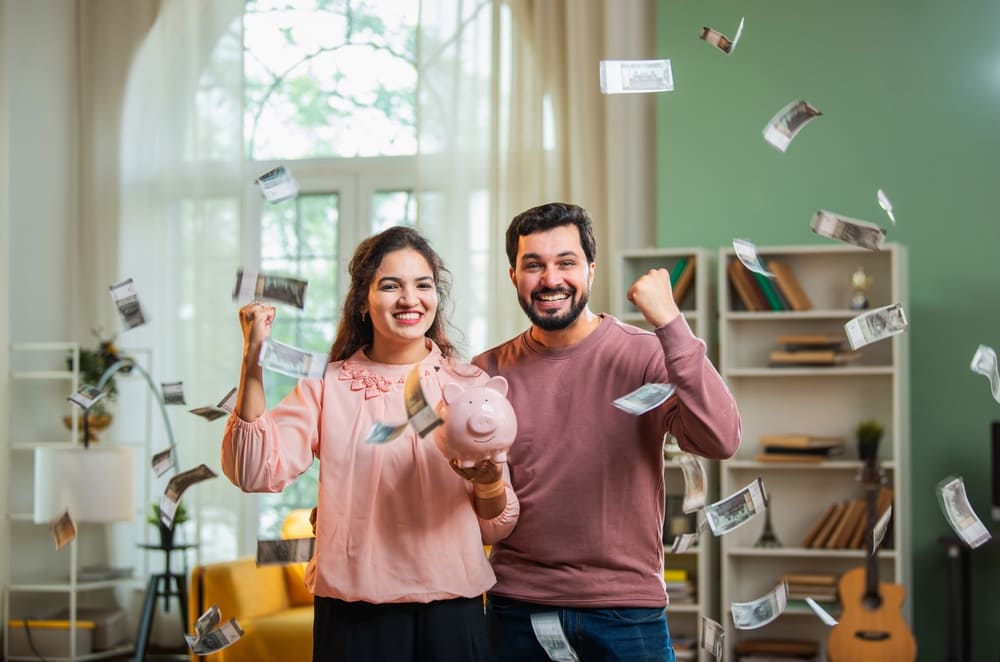 Pareja sonriendo mientras invierte en un CDT digital desde la aplicación móvil de su banco.